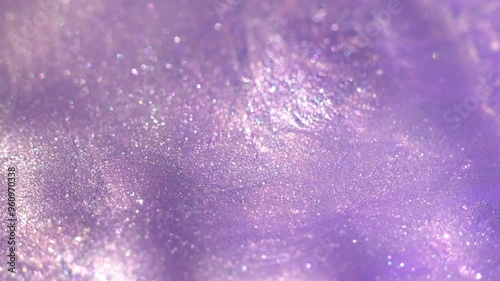 Pastel lilac color liquid pearls paint. Ink flow macro. Glitter fluid motion. Beautiful glitter abstract background