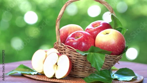 Fresh Red Japanese Apple on blurred greenery background, Shinano Red and Sansa Apple in basket on wooden table in garden.