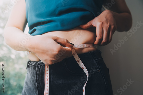 fat woman, fat belly, chubby, obese woman hand holding excessive belly fat with measure tape, woman diet lifestyle concept