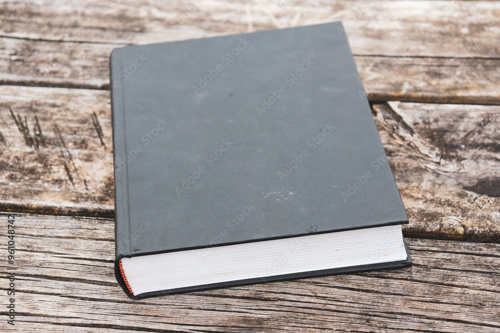 Fototapeta premium old hardcover book on outdoor wooden table