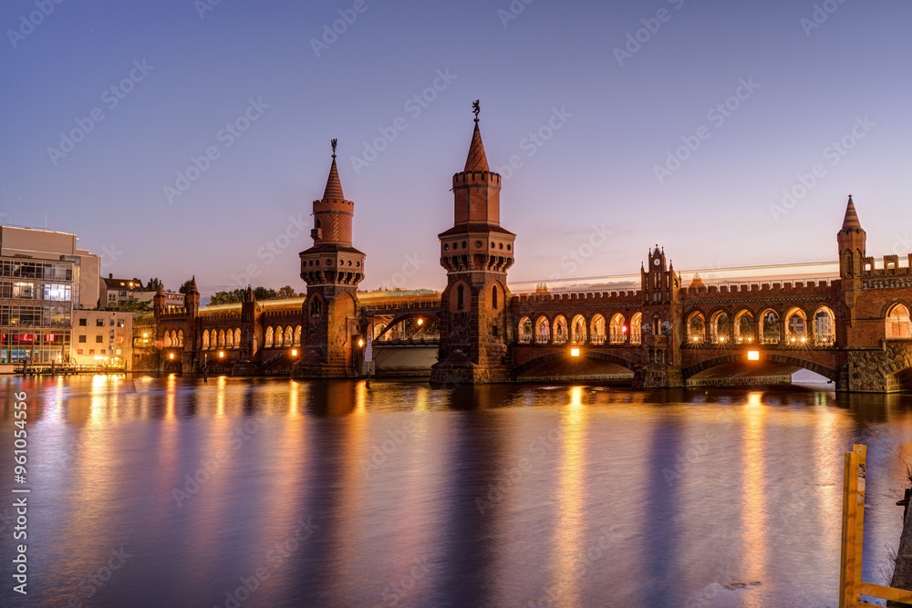 Fototapeta premium The Oberbaumbruecke over the river Spree in Berlin at twilight with a motion blurred subway