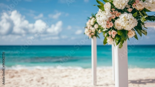 white floral archway with ocean and beach blurred background for tropical wedding ceremony photo