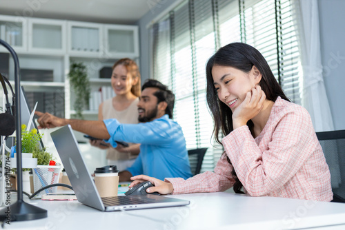 Happy young attractive asian businesswoman using laptop at office table. company employees sitting at work, Female accounting working towards marketing.