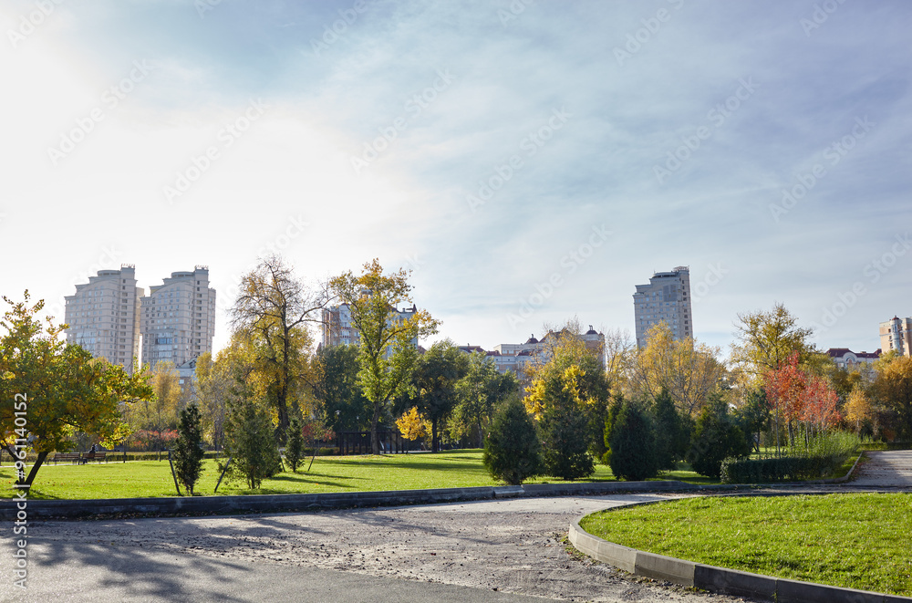 Walkway surrounded by trees and lawns in Kyiv, Europe. Recreation place in the autumn city park Walkway surrounded by trees and lawns in Kyiv, Europe. Recreation place in the autumn city park