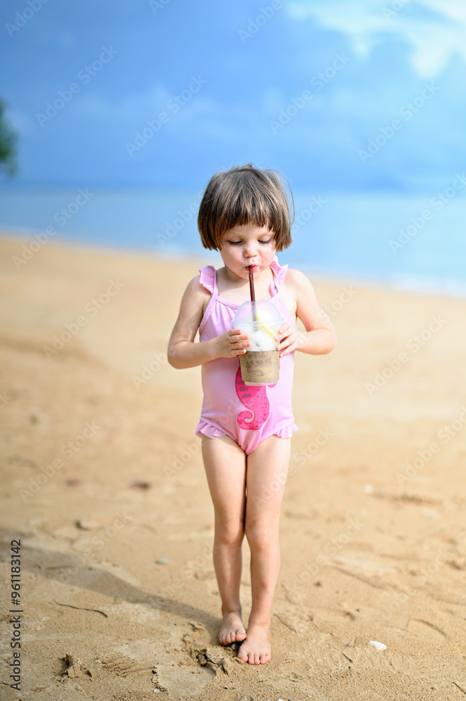 Kid girl on the beach with juice Kid girl on the beach with juice