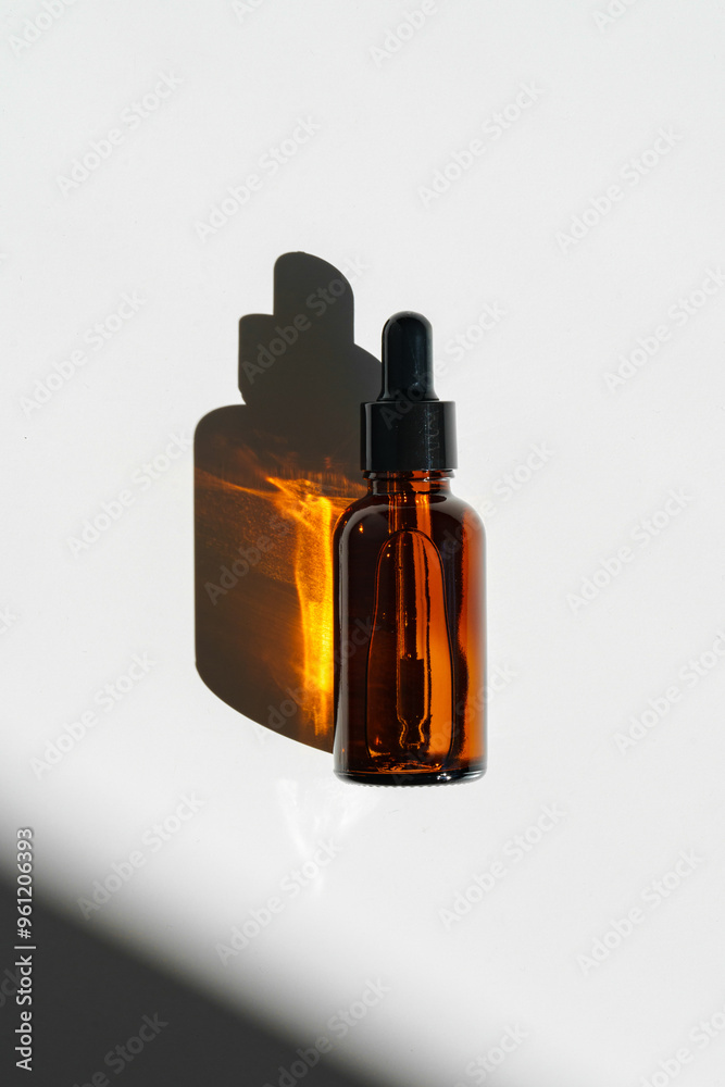 Aromatic Essential Oil Bottle With Dropper on White Surface in Bright Natural Light Aromatic Essential Oil Bottle With Dropper on White Surface in Bright Natural Light
