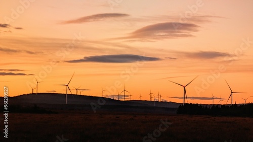 Obraz na płótnie Wind turbines on wind farm under beautiful orange sunset sky at Galway, Ireland, green energy, environment, nature background w salonie