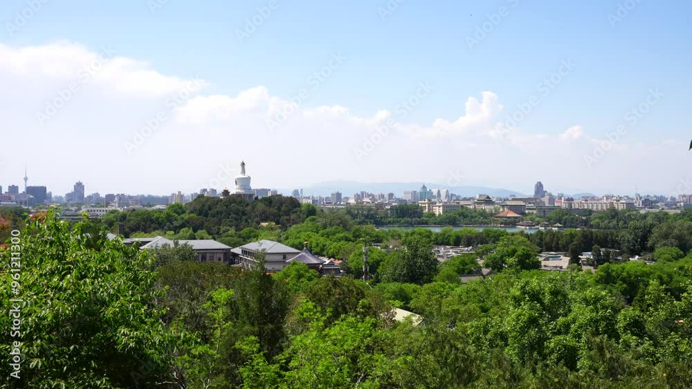 Zoom in shot to Beihai White Tower seen from a lush green hilltop with Beijing skyline in the distance, China Zoom in shot to Beihai White Tower seen from a lush green hilltop with Beijing skyline in the distance, China