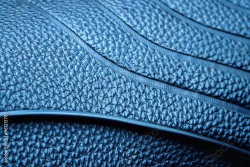 The blue leather has a pattern of lines and dots. The image has a mood of sophistication and luxury