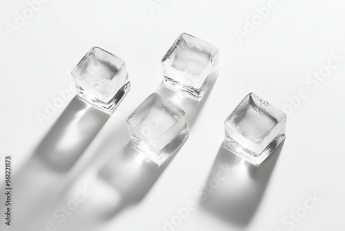 Four ice cubes arranged on a white background, casting subtle shadows.