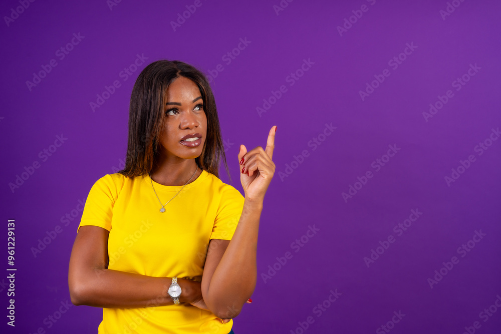 African woman looking up and pointing with finger African woman looking up and pointing with finger