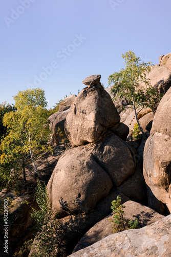 A picturesque rock formation surrounded by lush greenery.
