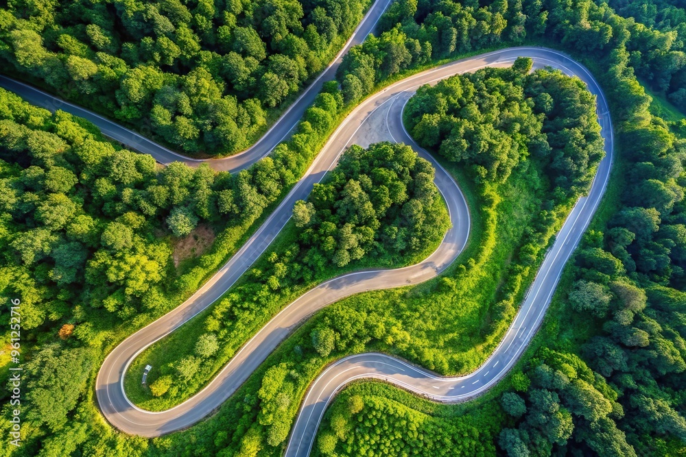 Aerial view of a winding ribbon road through lush green landscape Aerial view of a winding ribbon road through lush green landscape