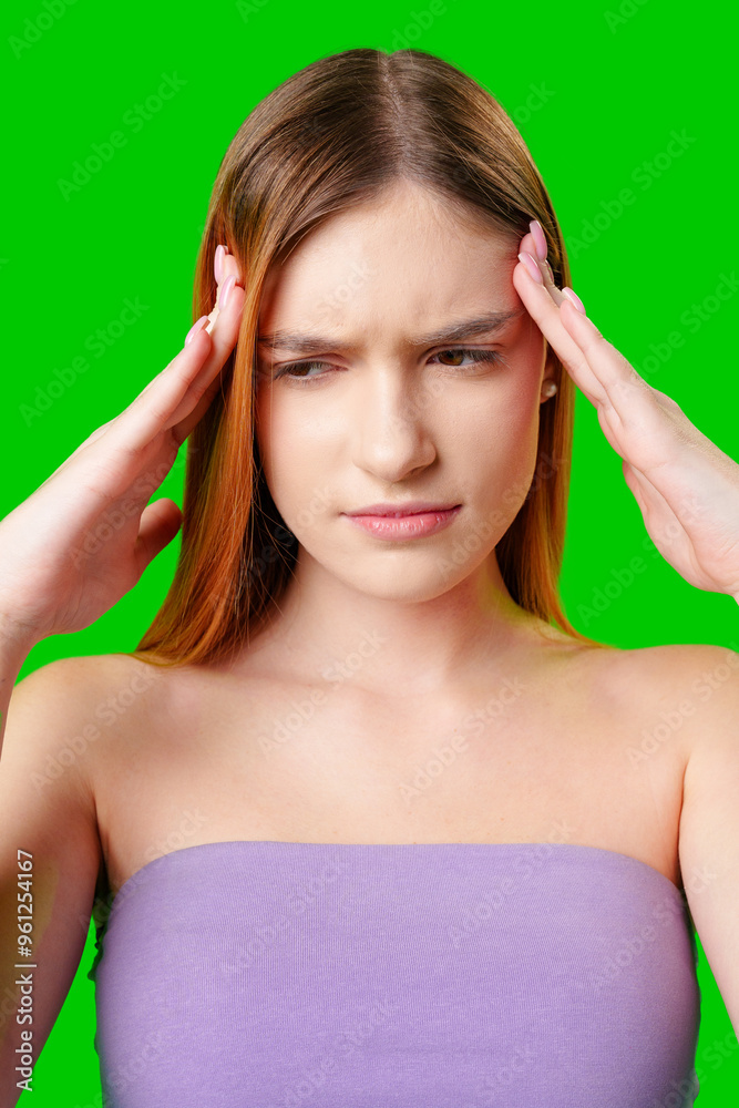 Young Woman With Headache Holding Her Temples Against a Green Background Young Woman With Headache Holding Her Temples Against a Green Background