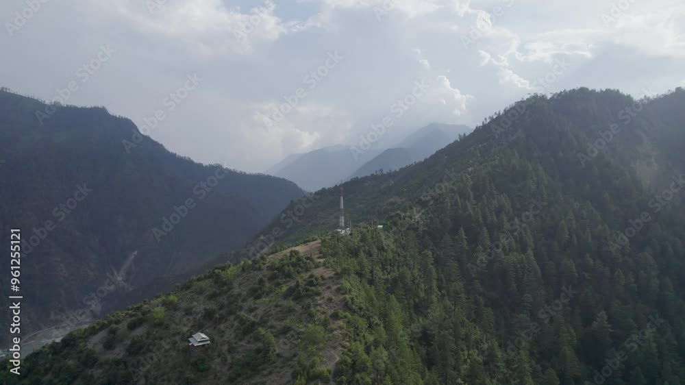 Mobile Network tower on the top of the mountain with surrounding mountains and Village houses Mobile Network tower on the top of the mountain with surrounding mountains and Village houses