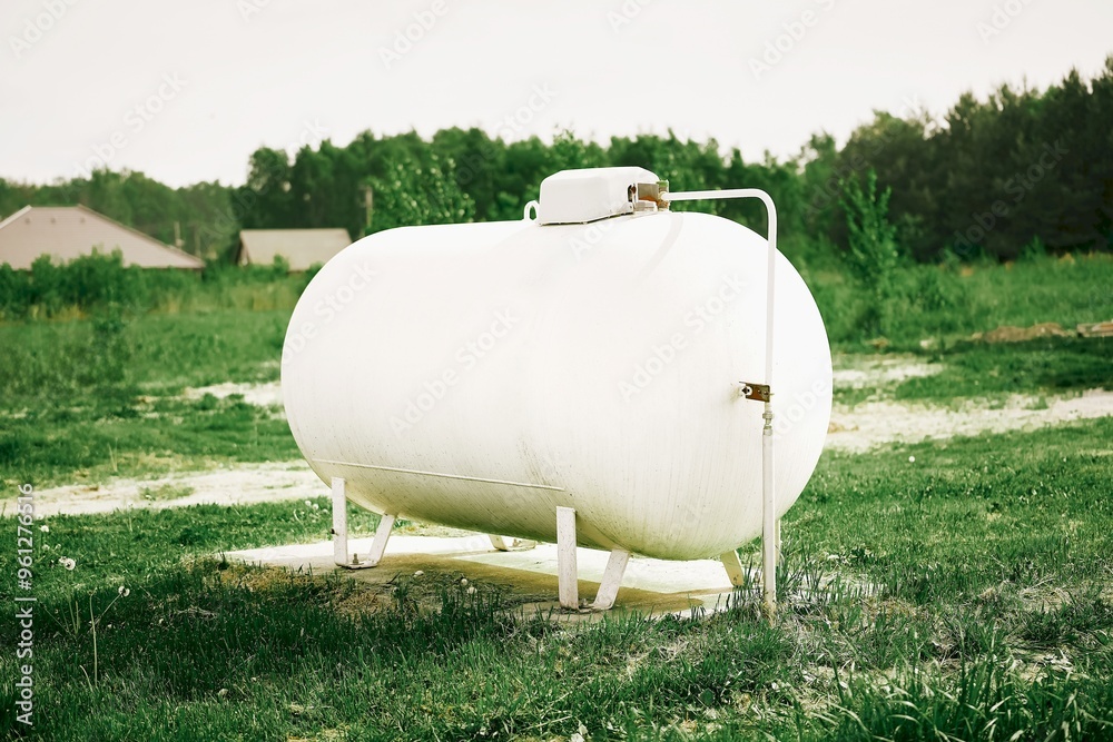Large white propane gas tank providing clean energy to a rural home Large white propane gas tank providing clean energy to a rural home