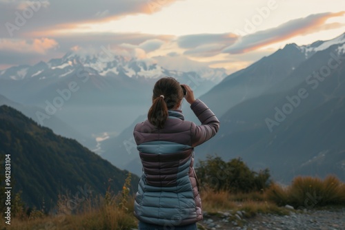 A woman embraces self-love and healing while capturing beautiful mountain vistas at sunset, reflecting on mental wellness in nature