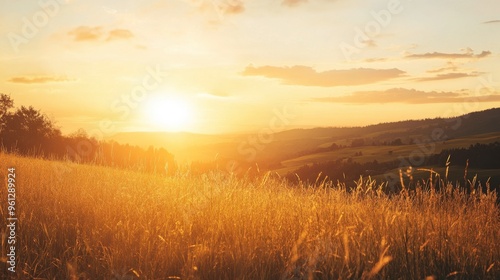 A clear sky during sunset, with a warm golden glow spreading across a tranquil landscape.