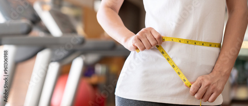 Diet and dieting. Beauty slim female body use tape measure. Woman in exercise clothes achieves weight loss goal for healthy life, crazy about thinness, thin waist, nutritionist. photo