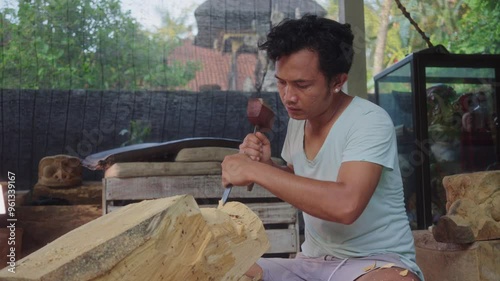 Get an up-close view of a Balinese artist carving a Barong wood mask. Intimately captures each precise movement, highlighting the artistry and cultural importance in Balinese rituals. photo