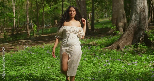 A young Latina girl, clad in a dress, finds joy in the serene environment of a Caribbean park on Trinidad Island. photo