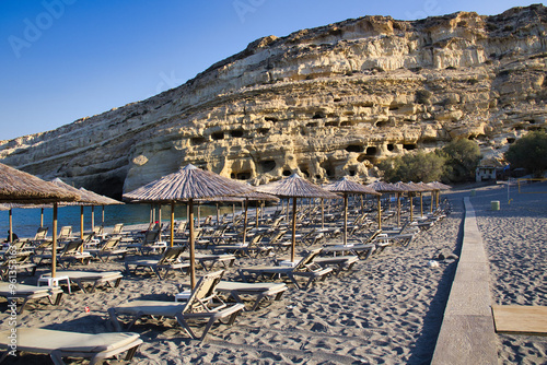 Matala bay and beach with caves on the rocks, in morning sun. Crete, Greece 2024