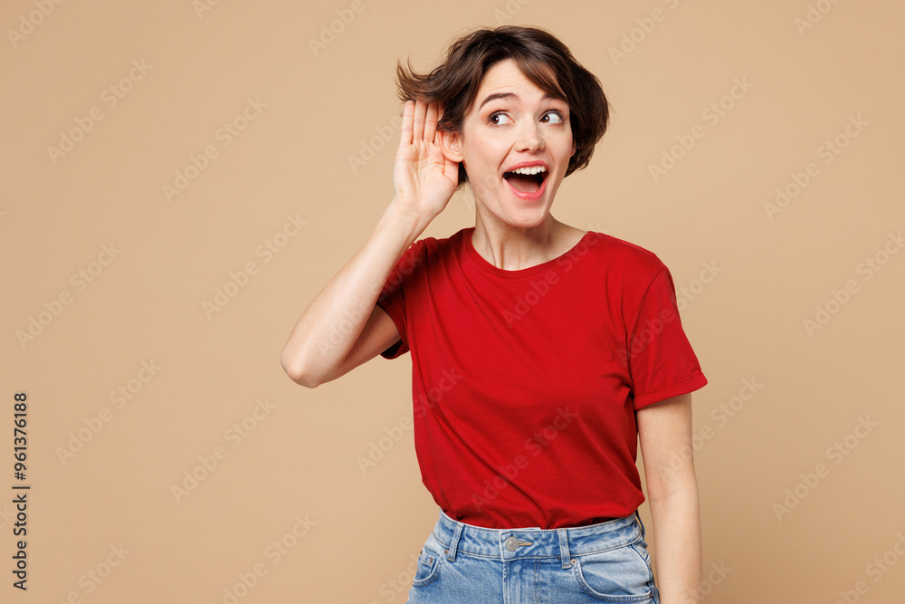 Φωτογραφία Young curious nosy fun happy woman she wear red t-shirt casual clothes try to hear you overhear listening intently isolated on plain pastel light beige background studio portrait