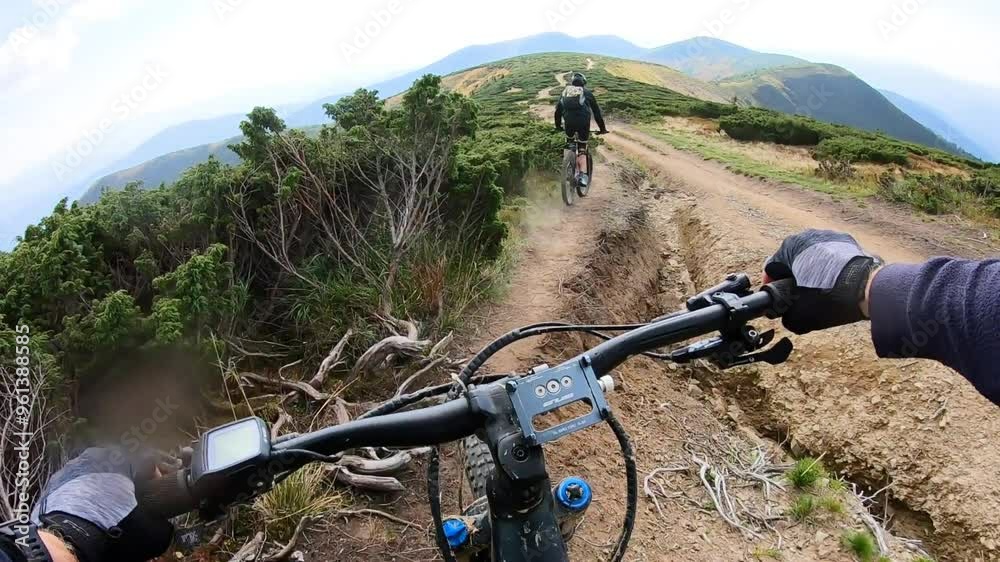 Point of view. Couple of cyclist riding electric mountain bikes in the mountains. Concept of adventure, leisure time outdoors. Point of view. Couple of cyclist riding electric mountain bikes in the mountains. Concept of adventure, leisure time outdoors.