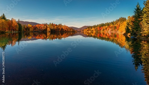 Scenic shot of a calm lake with fall reflections
