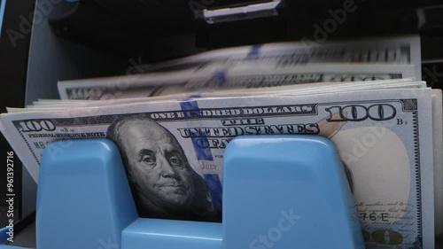 ATM dispenses cash during a busy afternoon in downtown, showcasing bills being withdrawn