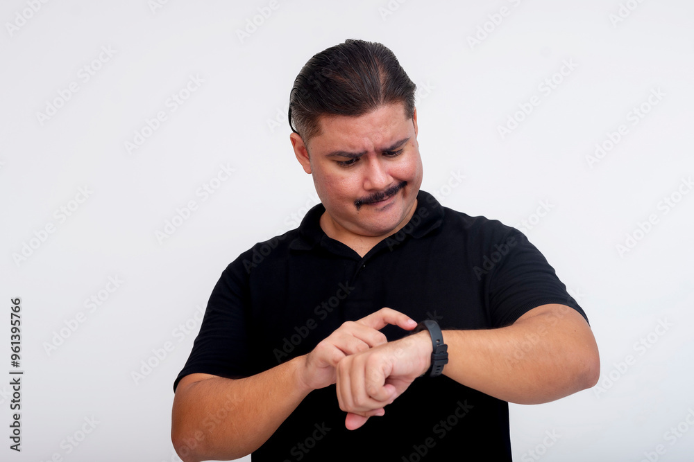 A middle aged man looking frustrated while trying to operate a smartwatch or band. Isolated on a white background. A middle aged man looking frustrated while trying to operate a smartwatch or band. Isolated on a white background.