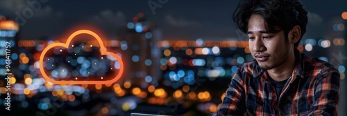 Young Man Focused on Laptop With City Lights and Cloud Icon Technology, Remote Work Concept