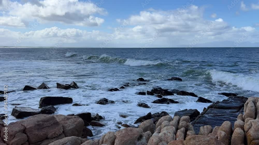 Rolling blue waves washing over the rocks and boulders Rolling blue waves washing over the rocks and boulders