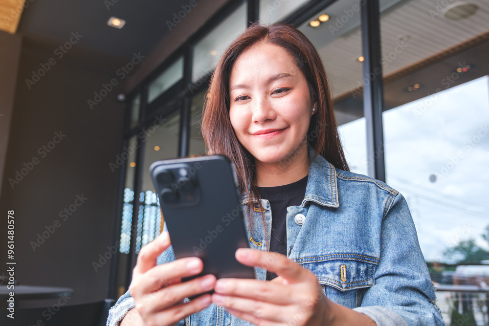 Portrait image of a young woman holding and using mobile phone in cafe Portrait image of a young woman holding and using mobile phone in cafe