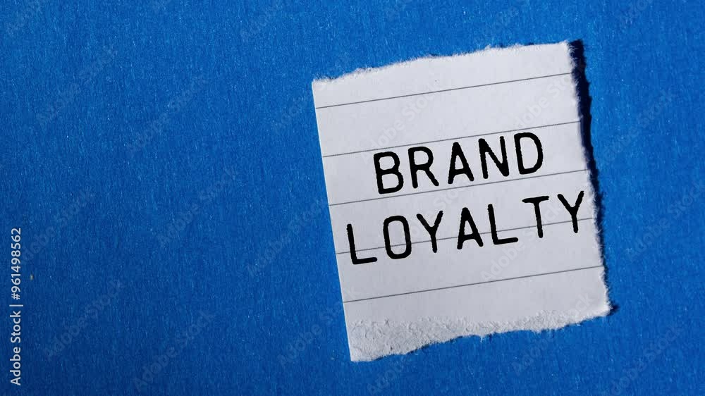 Brand loyalty message writing on ripped torn paper piece on blue background. Conceptual brand loyalty symbol.