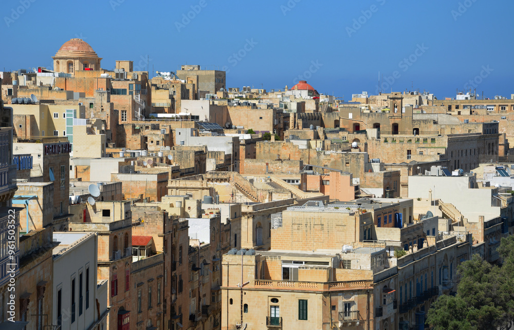 A high angle view of the crowded urban landscape of Valletta, the capital city of Malta, under a clear blue sky. A high angle view of the crowded urban landscape of Valletta, the capital city of Malta, under a clear blue sky.