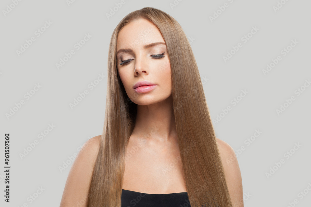 Healthy woman face. Model with long brown hair and make-up on grey background. Beauty, hair care and cosmetic portrait Healthy woman face. Model with long brown hair and make-up on grey background. Beauty, hair care and cosmetic portrait