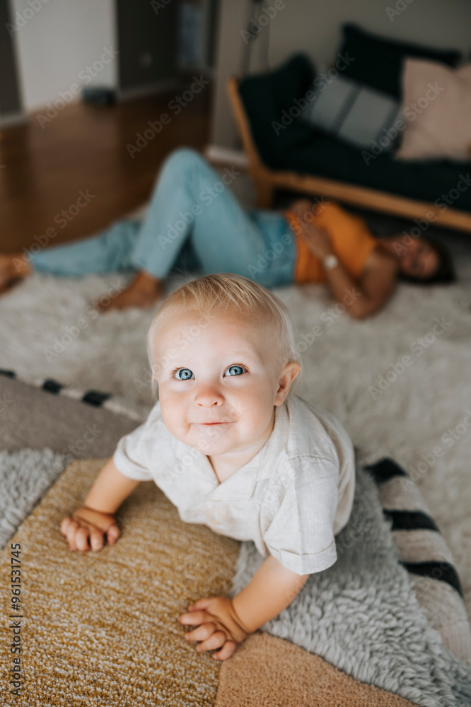 Cute toddler boy looking away while crawling on couch at home