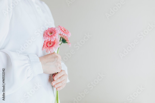 白背景、横向き、ガーベラの花束を持つ女性