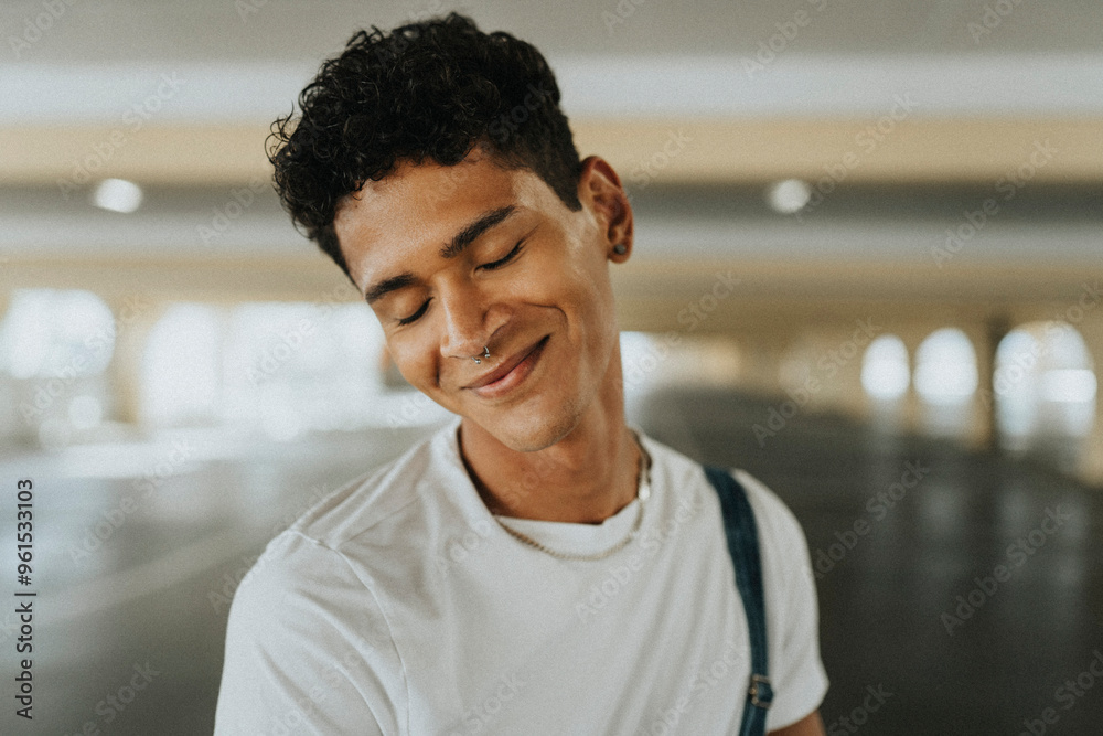Smiling young man with eyes closed and pierced nose at parking garage Smiling young man with eyes closed and pierced nose at parking garage