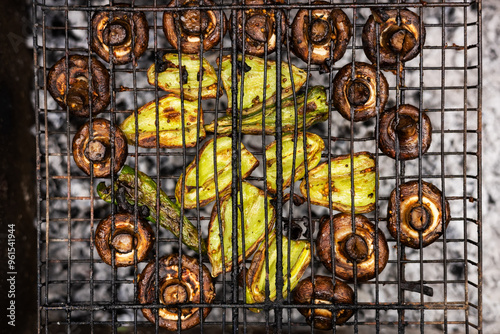 Grilled mushroom slices and pepper on a grill grate photo