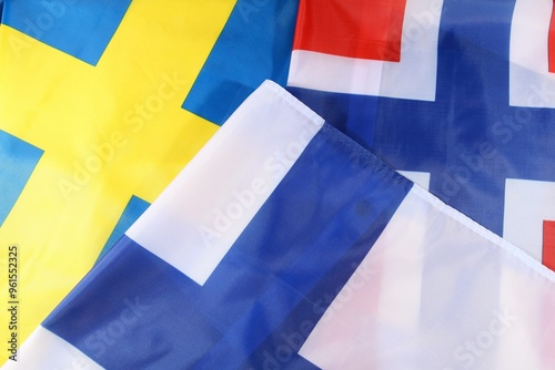 Colorful flags of Sweden and Finland displayed together on a surface photo