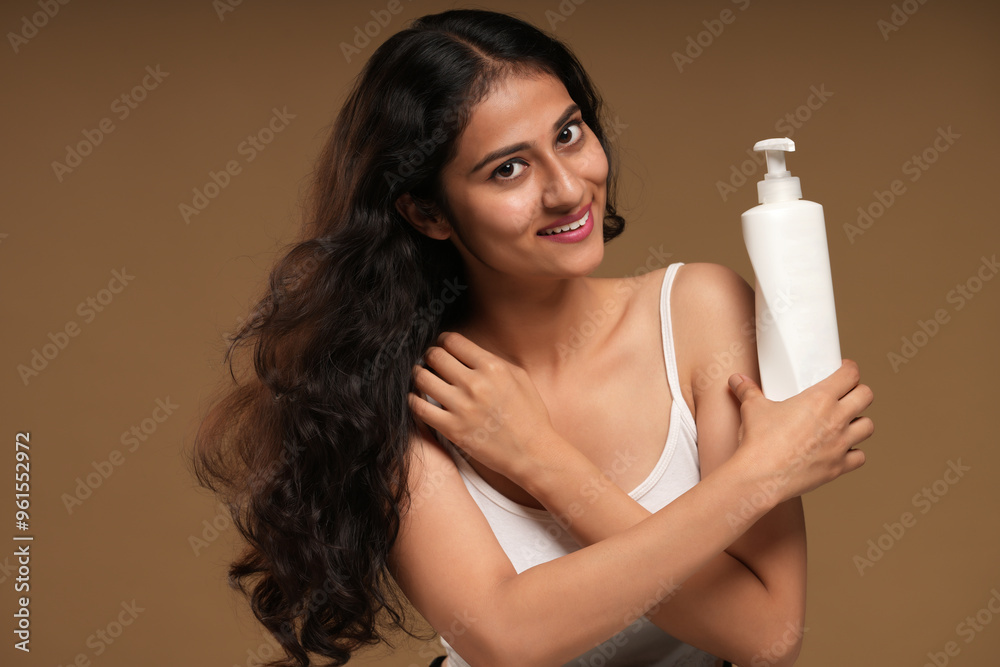 portraits of a young woman holding bottle of body lotion portraits of a young woman holding bottle of body lotion