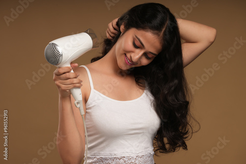 young woman using hair dryer 