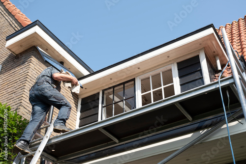 Construction worker walks up a ladder with a new window with rod division. Renovation house with double glazing