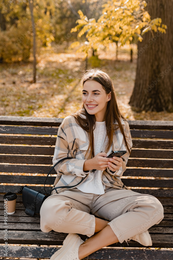 attractive young woman walking in autumn wearing jacket using phone attractive young woman walking in autumn wearing jacket using phone