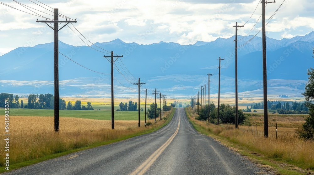 Row of electric poles along a rural road, with fields and mountains in the distance Row of electric poles along a rural road, with fields and mountains in the distance