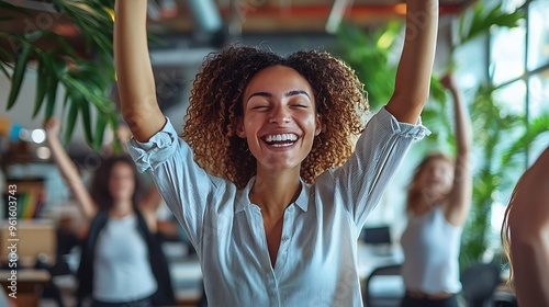 A happy female coworker celebrates success in the office, radiating enthusiasm and joy.