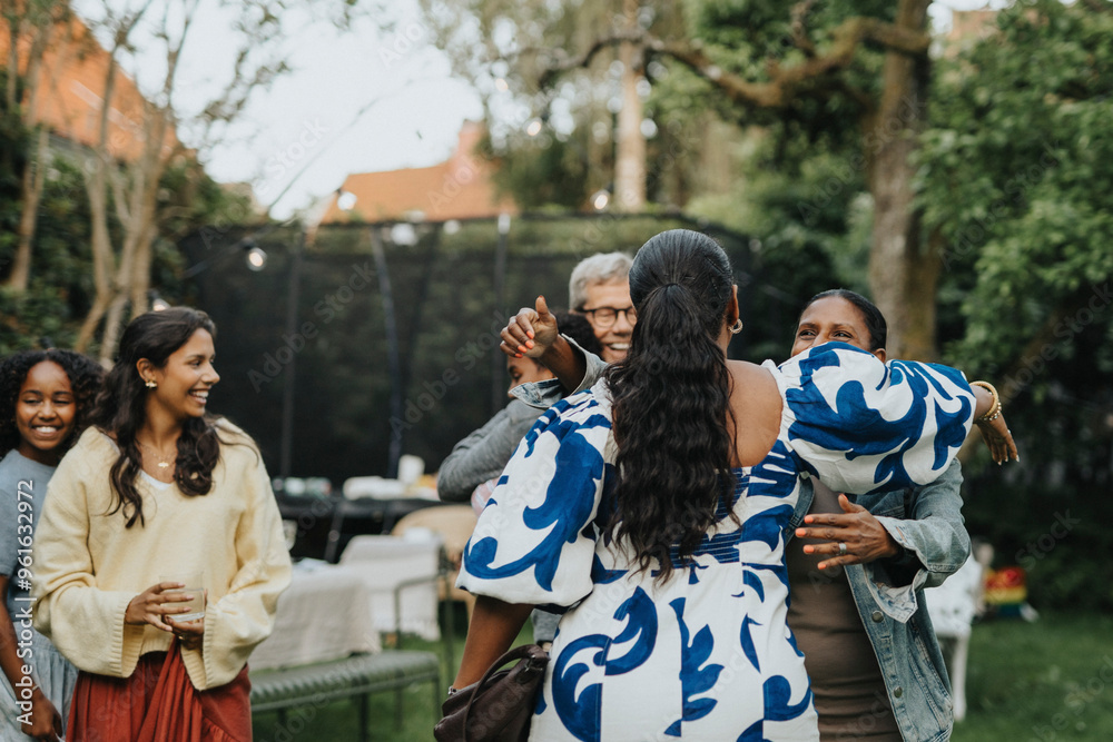 Family members greeting each other during social gathering in back yard Family members greeting each other during social gathering in back yard