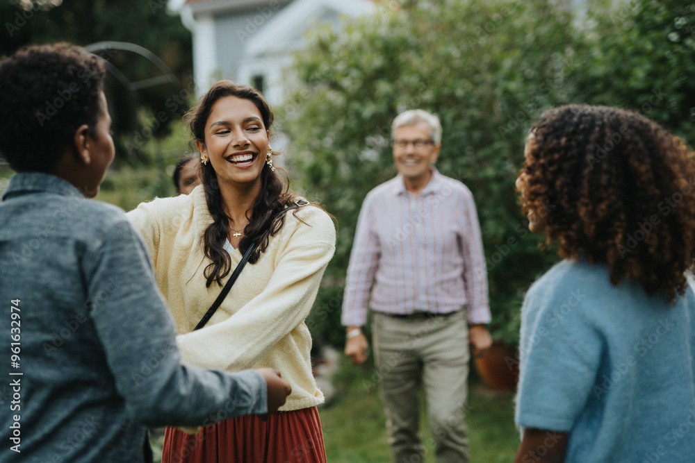 Cheerful teenage girl greeting family members at social gathering in back yard Cheerful teenage girl greeting family members at social gathering in back yard